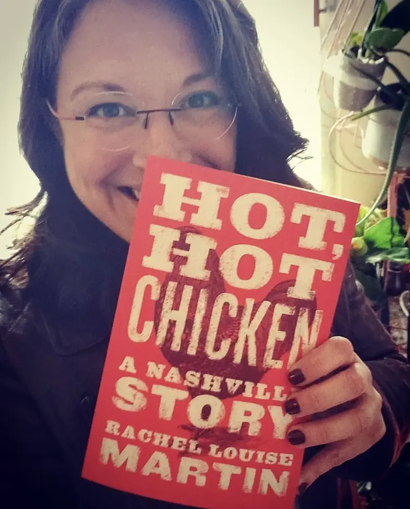 Tour guide Rachel L. Martin holding her book Hot, Hot Chicken