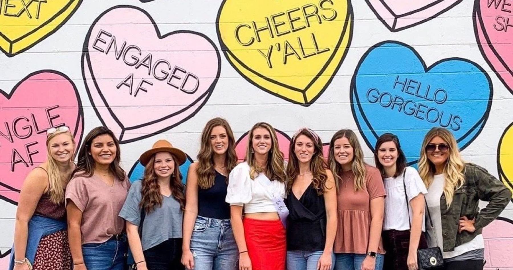 A group posing at a Nashville mural on the Murals and Mimosas tour