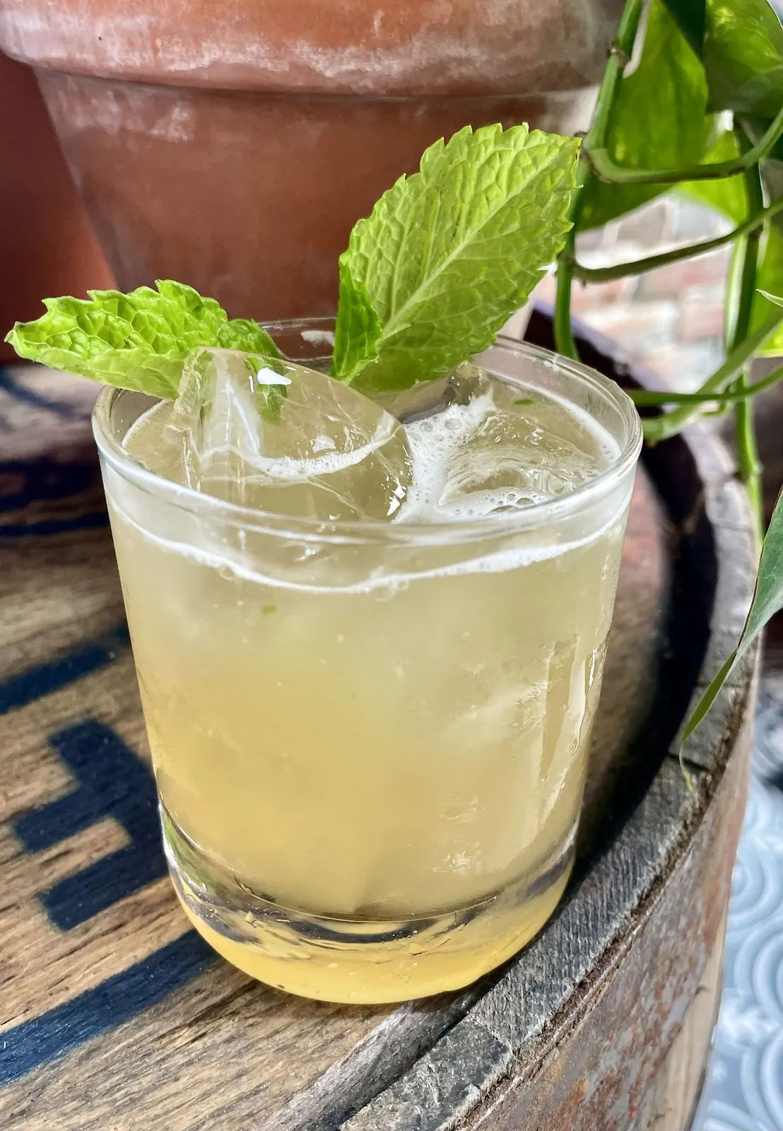 A mint-garnished whiskey cocktail on a barrel at a downtown Nashville distillery